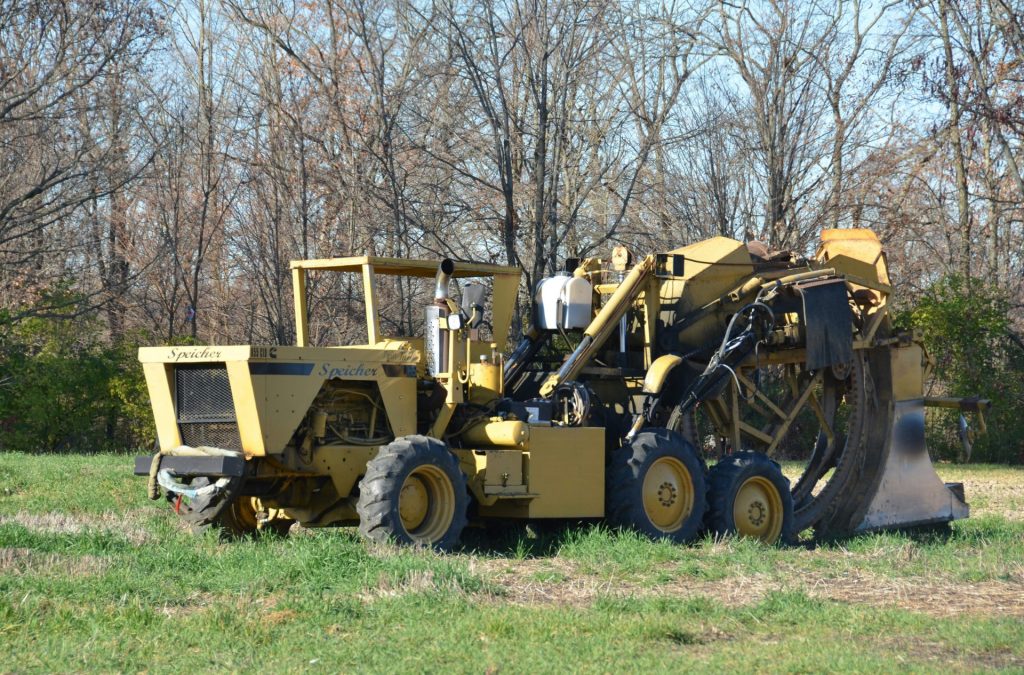 un tracteur est garé dans un champ avec des arbres en arrière-plan